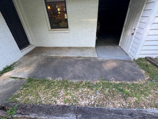 Side of a house with white vinyl siding heavily stained with dirt and mildew before washing.