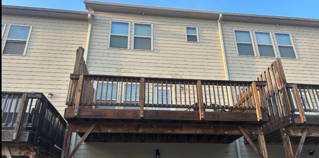 Elevated wood deck and railing on a multi-unit residential building.