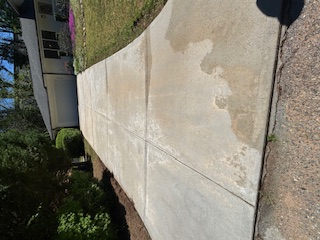 Long residential concrete driveway leading toward a garage.